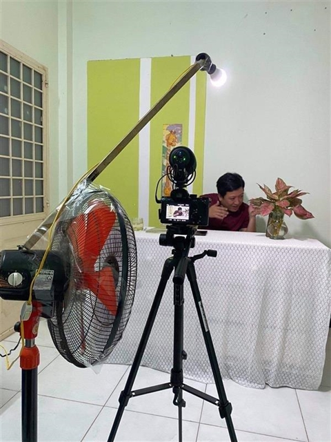 Ведущий Чыонг Джанг из шоу Nhanh Như Chớp настраивает оборудование для подготовки к съемкам дома. 
